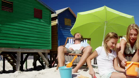 Girl playing with her mother at beach alt