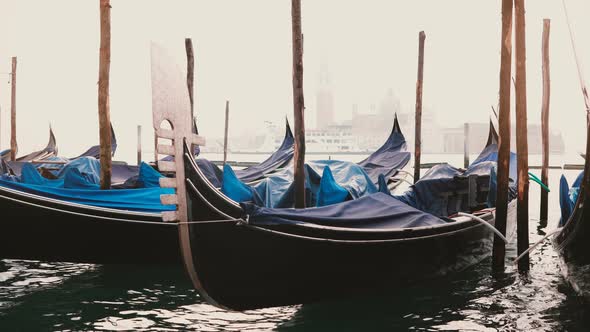Atmospheric View of Beautiful Traditional Gondolas Rocking on the Waves at Foggy Wooden Lagoon Pier alt