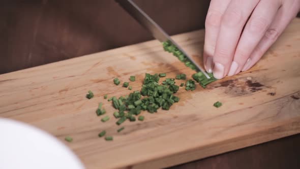 Step by step. Chopping fresh chives on cutting board for garnishing American style creamy mashed pot alt