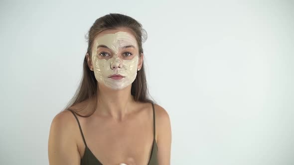A Young Beautiful Girl Applies a Moisturizing Mask to Her Face with a Brush alt