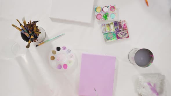 Flat lay. Little girl painting with acrylic paint on canvas with her mother for a distant learning a alt