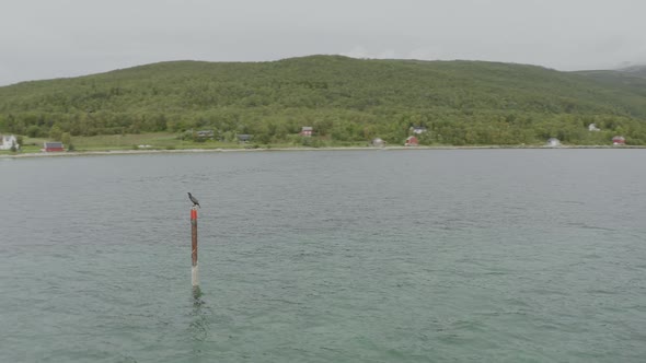 Boat pulling away from Finnkroken Island with misty mountain backdrop. alt