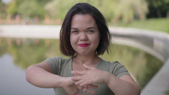 Front View Positive Little Person with Dwarfism Stretching Hands Looking at Camera Smiling in Slow alt