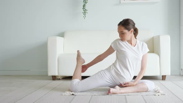 Calm Pregnant Woman Does Ardha Matsyendrasana Pose at Home alt