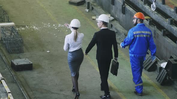 Factory managers giving tour to foreign colleague