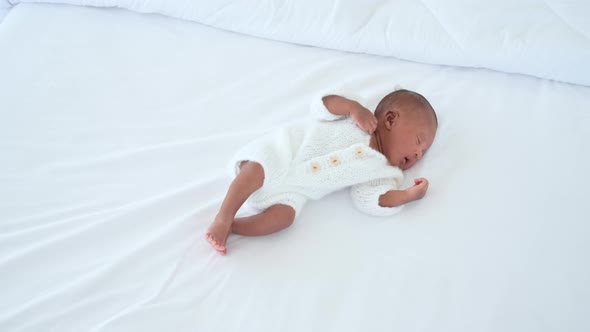 African American newborn baby sleep on white bed then wake up with crying alt