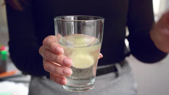 Close Up of Woman Dropping Effervescent Tablet in Glass with Water