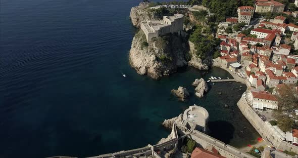 Aerial shot of Dubrovnik Old town, the camera rises slowly to reveal the ancient fort. alt