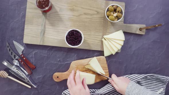 Time lapse. Flat lay. Arranging gourmet cheese, crakers, and fruits on a board for a large cheese bo alt