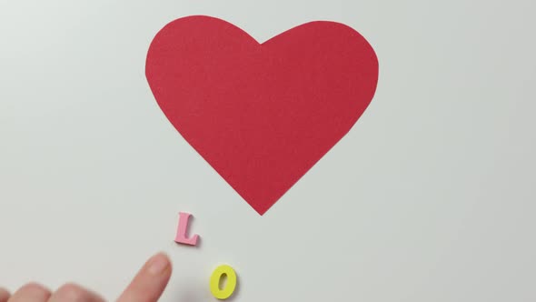 Red Paper Heart on White and Colorful Letters Love Under Concept Relationships alt