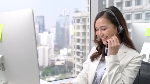 Friendly beautiful Asian businesswoman customer service operator smiling and talking