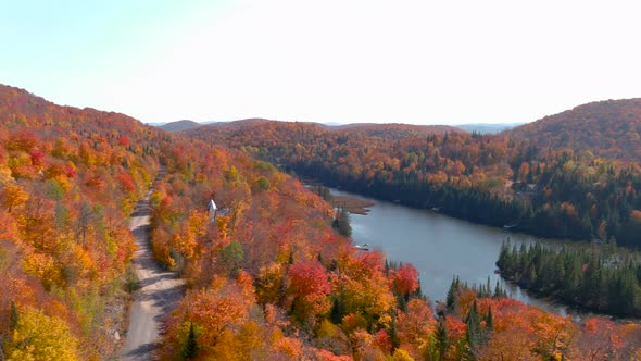 4K camera drone panning panorama view of stunning autumn foliage colors and a mountain lake.