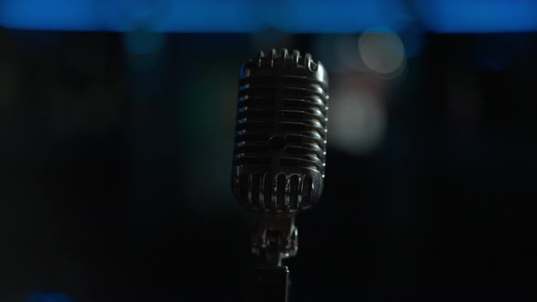 Closeup Acoustic Microphone with Stage Lights Turning Off at Background alt