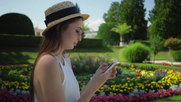 Girl Tourist Using Mobile in the Park of Lednice Palace Czechia alt