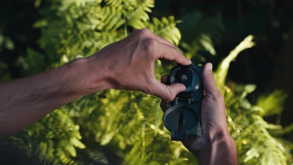 Hands of a Boy Opens the Compass in the Mountains to Orient Himself in the Hike alt