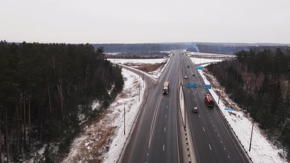 Wide Suburban Highway with Fast Moving Trucks and Cars in Winter Aerial View alt