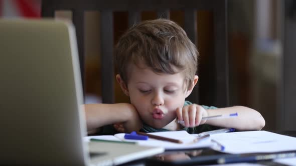 Little toddler boy is playing with pens on father's working place at home