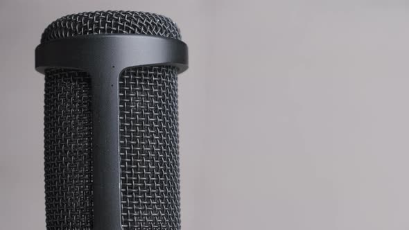 Studio Condenser Microphone Rotates on Gray Background with Place for Text alt