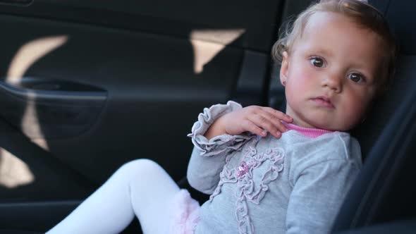 A Small Child is Sitting in the Car She is Watching Intently alt