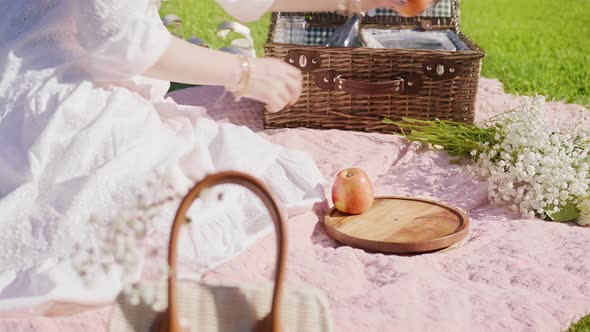 Woman Picking Fruits From Open Picnic Basket Placing on Wooden Plate at Summer alt