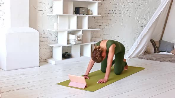 Slender Woman Practices Yoga Online Using a Digital Tablet