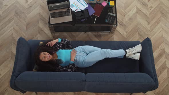 Overhead Portrait of Smiling African American Woman on Sofa alt