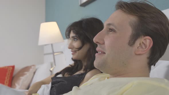 Fruit and TV enjoyment, a couple in the bedroom. alt