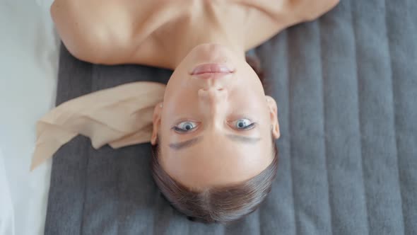 Beautiful Woman in White Dress is Lying on Bed alt