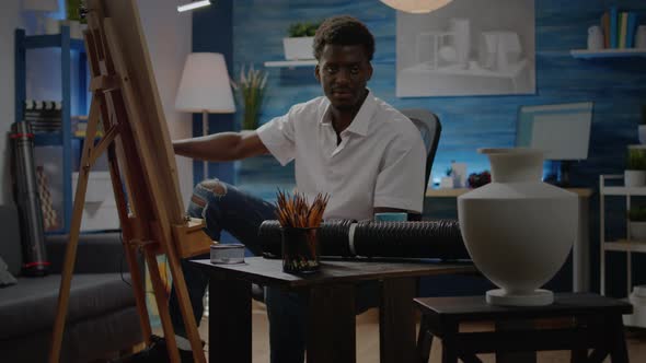 African American Person Drawing Vase Design on White Canvas alt