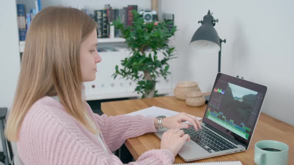 Female Creative Video Editor or Blogger Works with Laptop in Home Office