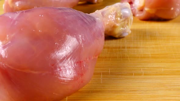 Fresh chicken legs on a cutting board. alt