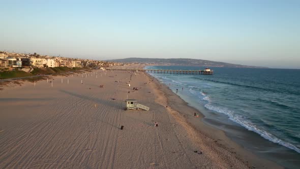 Beachgoers Relaxing At Manhattan Beach Pier At Dusk In California, USA. - aerial alt