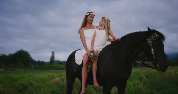 Happy woman and flower girl riding horse together alt