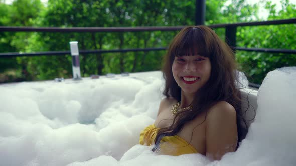 Cute Smiling Asian Girl in Bikini Relaxing in Hot Tube Thailand