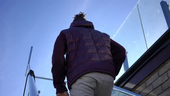 Successful Young Man Walking Upstairs to Sunny Terrace Leaving alt