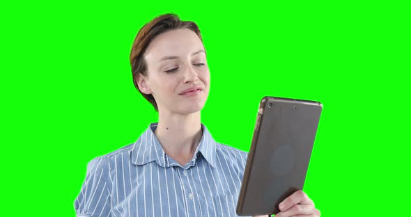 Caucasian woman using a digital tablet on green background