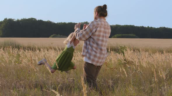 Young Dad Caucasian Man Father Daddy Holding Baby Daughter Little Girl By Arms Spins Rotates alt