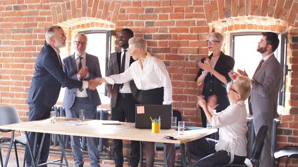 Group of Businessmen in Office Congratulate Colleague Who Sit at Table and Work To Laptop. alt