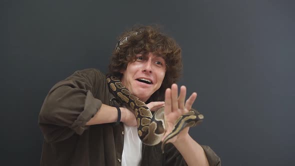 a Person Has a Panic Attack with a Snake in His Hands a Confused Guy Can't Move Makes a Funny Face