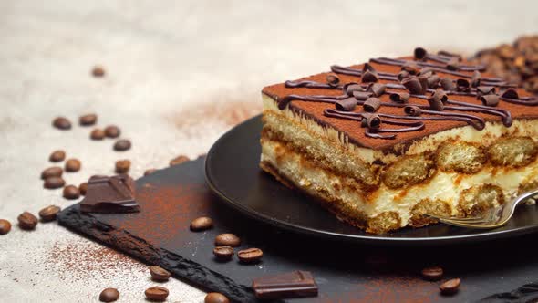 Portion of Traditional Italian Tiramisu dessert on grey concrete background alt