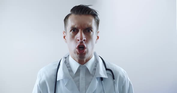 Closeup of Angry Doctor Scolding and Shouting at Employees Threatening with a Finger and Shouting alt