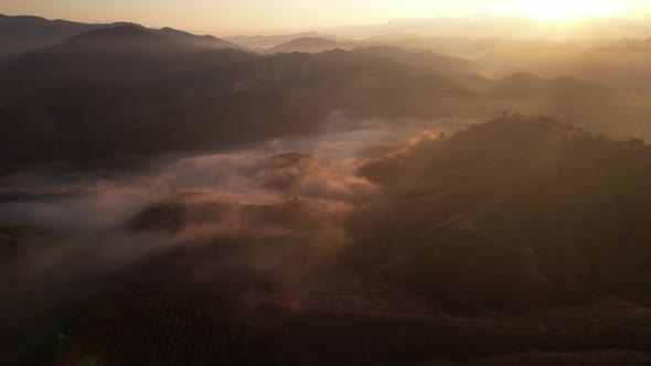 4K aerial view from a drone flying over the valley, fog in the morning. alt
