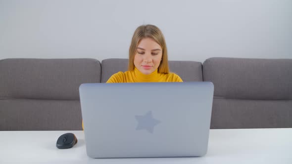 Young adult female doing freelance work on modern notebook computer at home in 4k footage alt