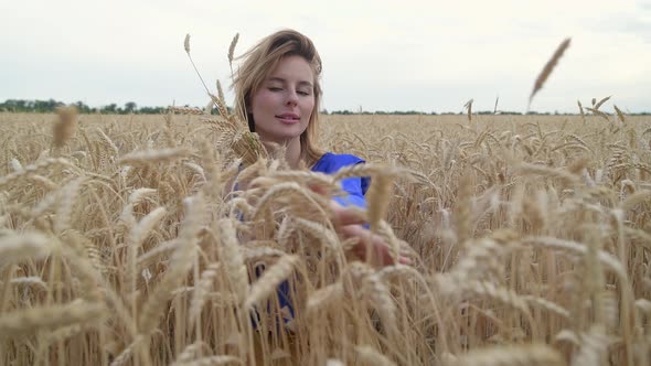 Beautiful Ukrainian Woman Wearing Dress in Ukrainian National Flag Colours Blue and Yellow at Wheat alt