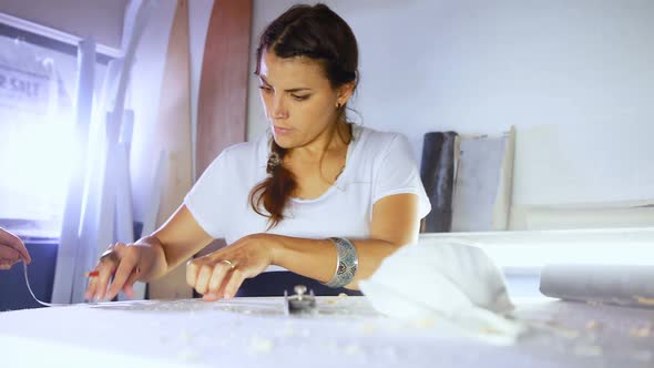 Woman and man making surfboard at workshop  alt