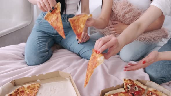 Close-up of Cut Takeaway Pizza Shared By Girls in the Bed alt