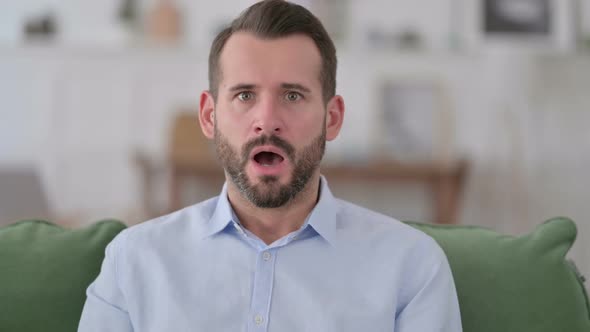 Young Man Feeling Shocked at Home alt