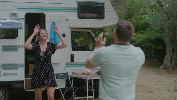 Pretty couple play volleyball together in nature enjoyng vacation near motor home RV campervan alt