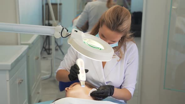 Cosmetologist Cleans Skin Using Ultrasonic Cleaning Device alt