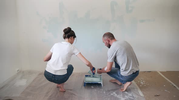 Caucasian Family Paints the Wall with a Roller Husband and Wife Together Make Repairs in the Room A
